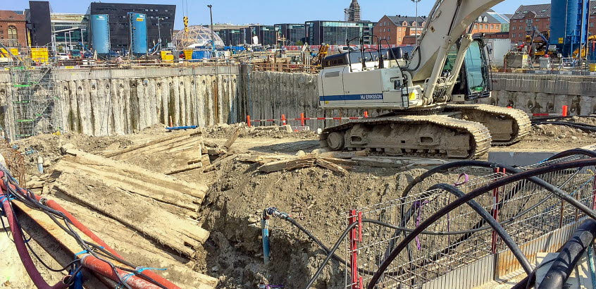 Stor schaktgrop och grävmaskin i samband med byggande av Metron i Köpenhamn