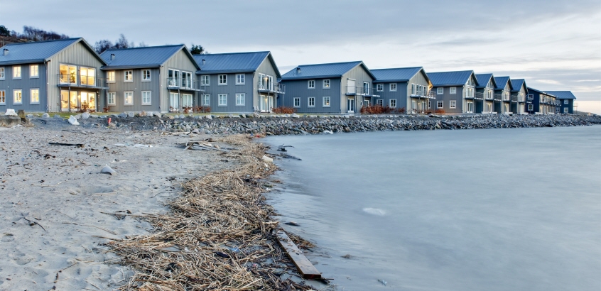 Flera hus på rad, byggda intill kusten.