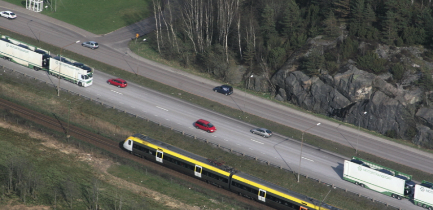 Flygfoto över trafikerad motorväg och järnväg vid Göta älv.