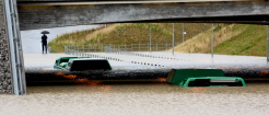 Buss sitter fast i vattenmassorna under en viadukt. 