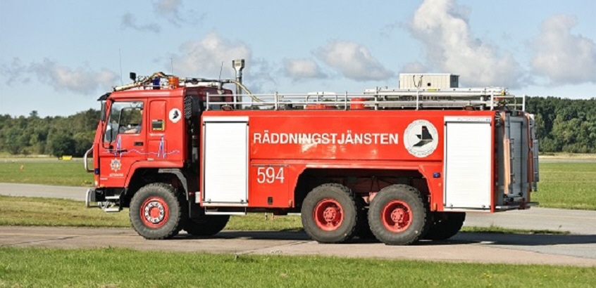 En räddningsbil står uppställd vid ett fält.