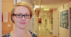 Porträttbild Rebecka Bertilsson, korridor i bakgrunden.
